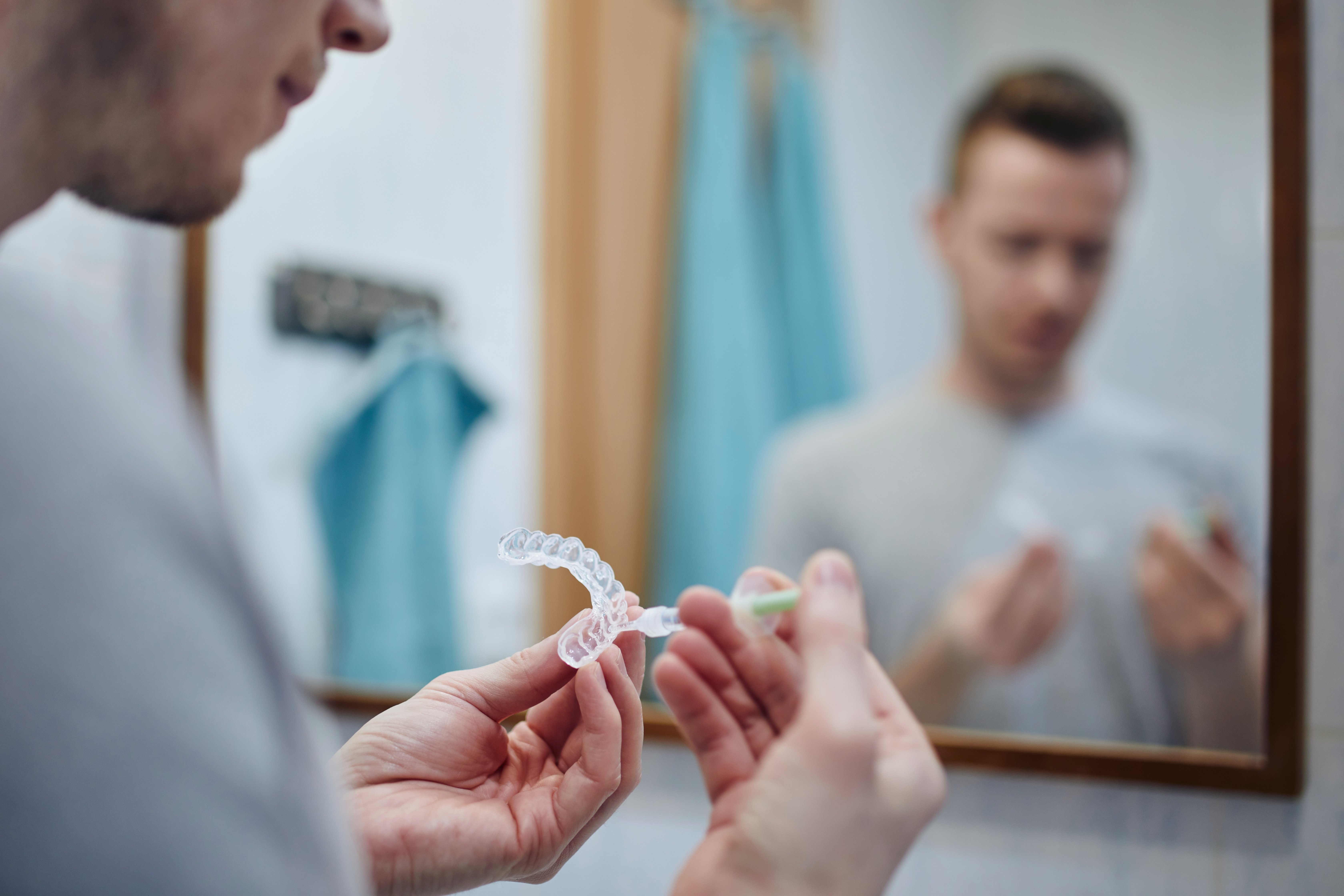 young-man-preparing-silicon-tray-teeth-whitening-bleaching-gel-syringe (1)